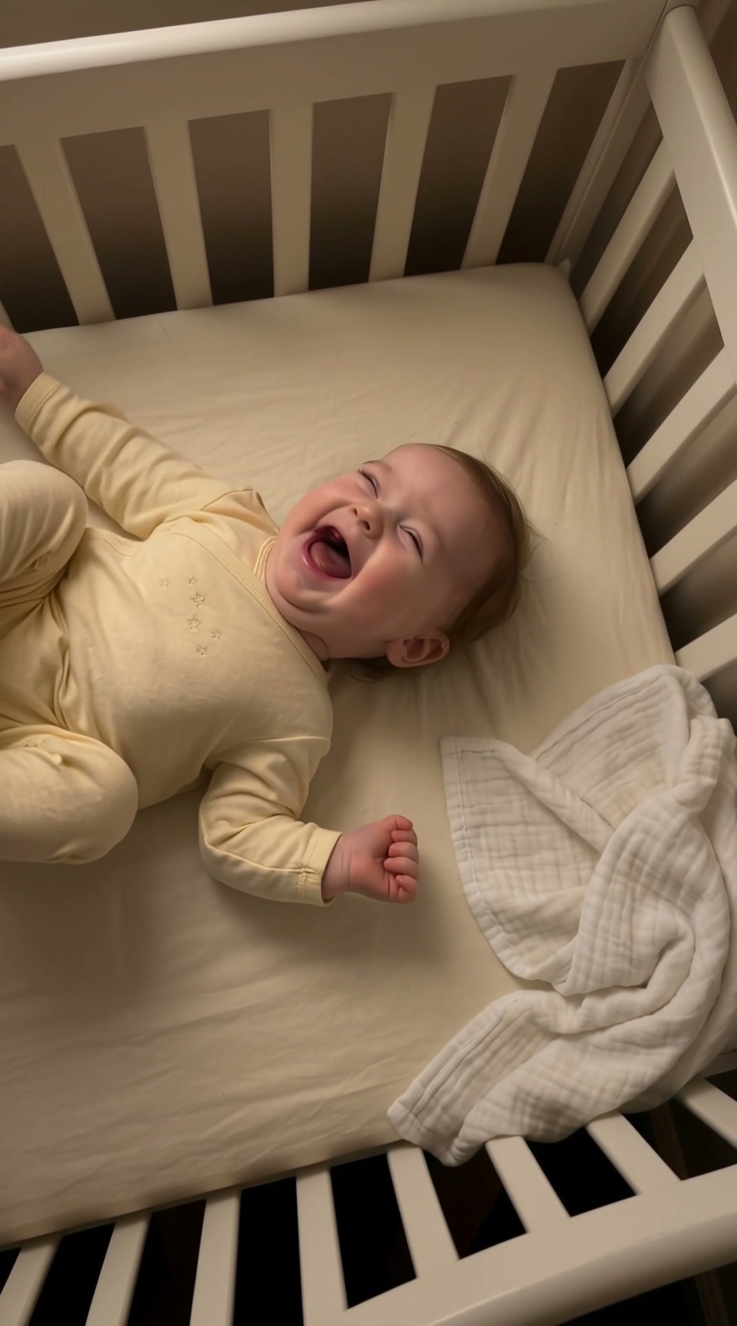 A baby caught mid-giggle in a crib